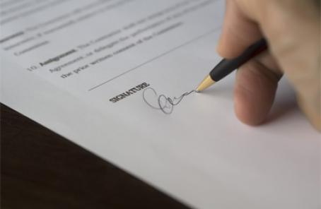 Stock image of person signing a form