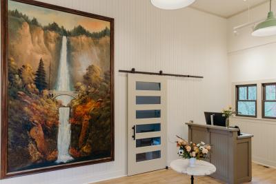 Interior view of the Gateway to the Gorge Visitor Center with a historic painting of Multnomah Falls and a reception desk